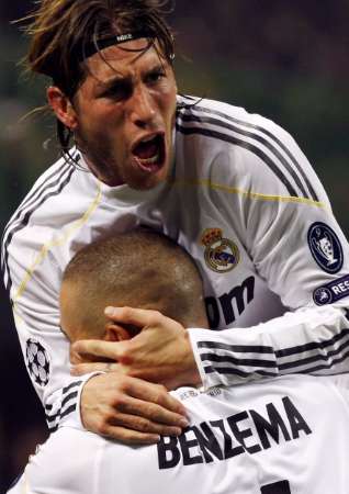 Real Madrid's Sergio Ramos jumping on Karim Benzema after the French striker opened the score line v AC Milan