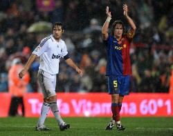 Real Madrid's captain Raul on the left and Barcelona's Carles Puyol on the right applauds to the crowd.