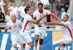 Tunisian players erupting in joy after scoring a crucial goal during the qualifiers.