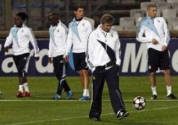 Real Madrid coach Manuel Pellegrini walking on the pitch with his players during training.