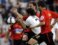 Real Madrid's Raul is challenged by Real Mallorca defenders during the last match-day of the 2006/07 La Liga season