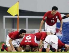 Egypt's players kneel down in prayer as they celebrate their comeback goal against Nigeria