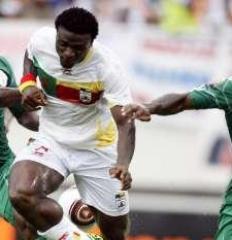 Benin player challenged by two Nigerian defenders.