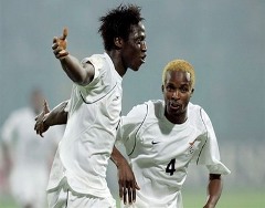 Zambian players celebrating after scoring a goal.