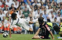 Real Madrid's Raul makes a fine tackle and falls on the ground as he challenges for the ball against Deportivo La Coruna