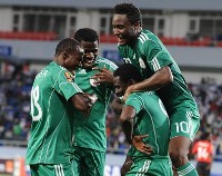 Nigeria's players celebrate together after scoring a goal.