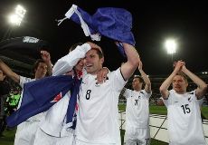 New Zealand's players celebrate with the country's flag as they qualify for the 2010 World Cup.
