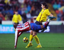Barcelona star Zlatan Ibrahimovic tackling a Sporting Gijon player for the ball