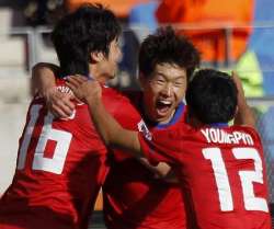South Koreans celebrating after scoring against Greece.