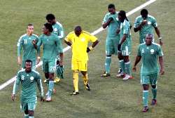 Nigerian players walk off the pitch disappointed after losing
2-1 to Greece.