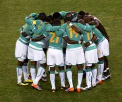 2010 World Cup: Cote d'Ivoire players together on the pitch, performing rituals for unity and strength ahead of their game against Brazil.