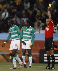 Referee showing the yellow card as two Cote d'Ivoire players
walk away.