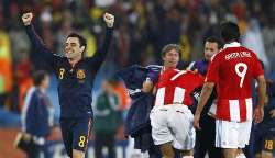 Xavi celebrates as Paraguayan players are dejected.