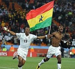 Ghana's Andre Dede Ayew Pele and John Paintsil celebrate vs USA holding the flag of Ghana as they run in the stadium.
