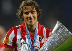 Diego Forlan of Atletico Madrid smiles as he lifts the UEFA Europa League trophy.