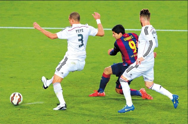 Luis Suarez shields the ball way from Pepe and Ramos 