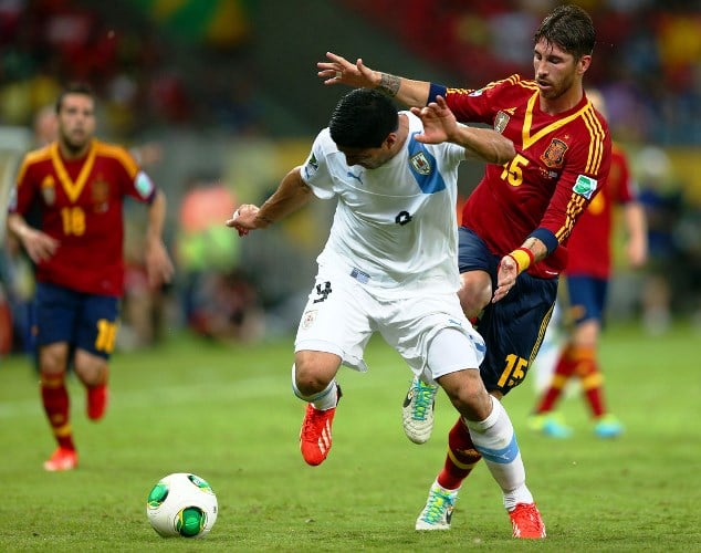 Luis Suarez of Uruguay shields the balls against Sergio Ramos of Spain