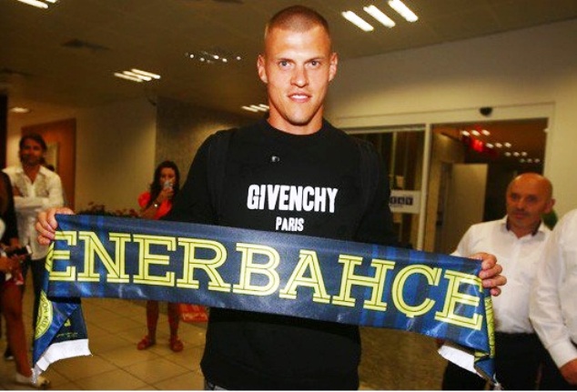 The Slovakia international poses with a Fenerbahce scarf moments after arriving in Istanbul 