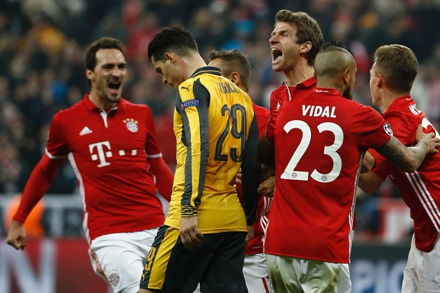 Granit Xhaka of Arsenal walks past Bayern Munich players as they celebrate scoring Thomas Muller's goal