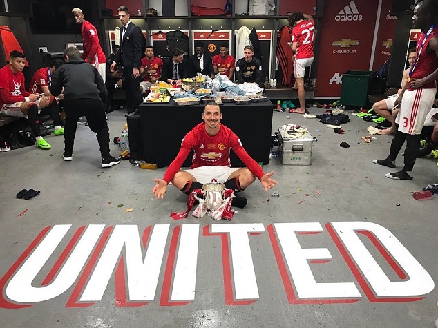 Zlatan poses with the League Cup trophy in the dressing room at Wembley
